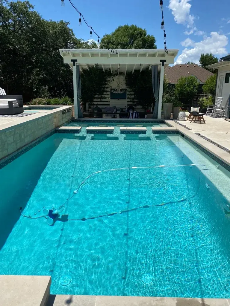 Bright-blue residential swimming pool beside an outdoor living space